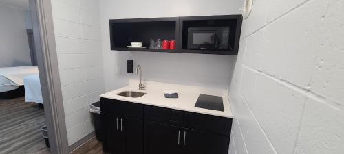 a bathroom with a sink and a black and white wall at Outer Banks Motor Lodge in Kill Devil Hills