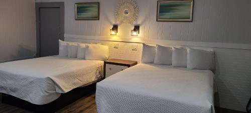 two beds sitting next to each other in a room at Outer Banks Motor Lodge in Kill Devil Hills