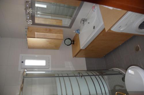 a small bathroom with a toilet and a sink at VILA KALIMERA private pool in Nea Potidaea