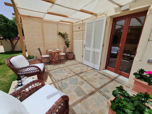 un patio con 2 sedie in vimini e un tavolo di Villa Manini suites a La Maddalena