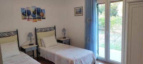 a bedroom with two beds and a large window at Villa Grecia in Liapades