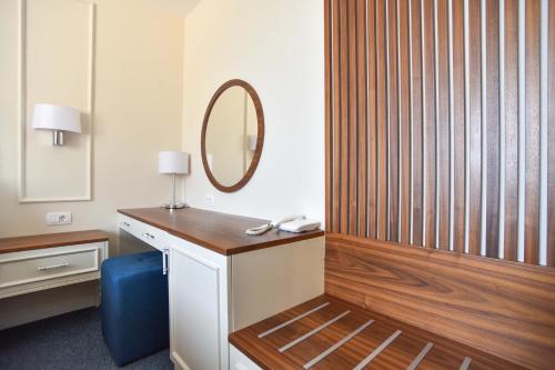 a bathroom with a mirror and a dressing table at Vistamar Hotel & Apartments in Budva