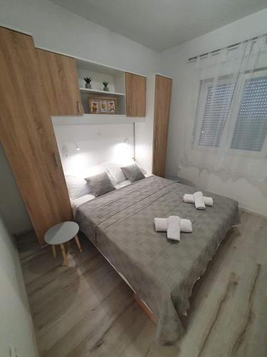 a bedroom with a large bed with two towels on it at Apartments MENA in Bibinje