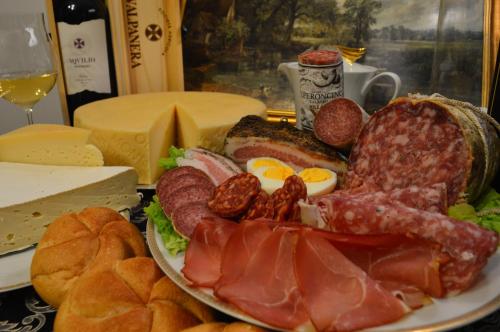 a plate of food with meat and eggs and bread at The White House Austria in Lind ob Velden