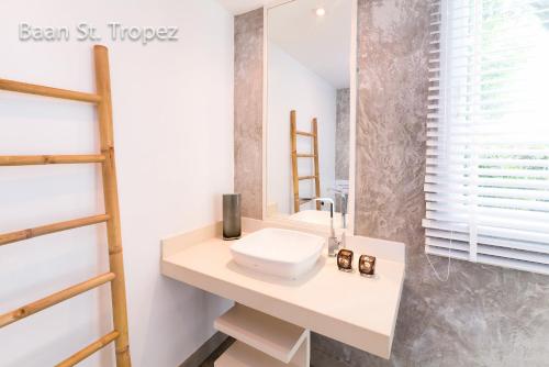 a bathroom with a sink and a mirror at Baan Saint-Tropez Seaview Villas Kata Beach in Kata Beach