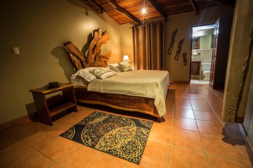 Un dormitorio con una cama con cabecero de madera. en Villas Oasis, en Manuel Antonio