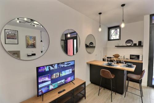 a living room with a tv and a table and chairs at La Sardine du Panier® in Marseille