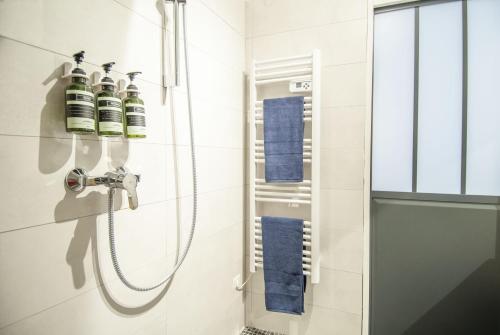 uma casa de banho com um chuveiro e toalhas azuis em La Sardine du Panier® em Marselha