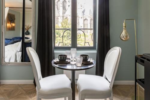 a dining room with a table and chairs and a window at 2 Appt MédiéLounge ou MédiéOld, Parking Vue magnifique par Beds76 in Rouen