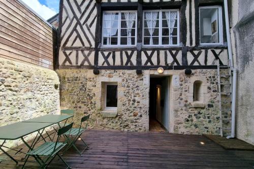 een gebouw met een tafel en stoelen op een houten terras bij La Terrasse Notre Dame - Karakteristiek huis - 4P - Centre Honfleur in Honfleur