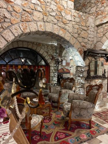 a stone room with chairs and a stone fireplace at Solomon&Sons in Dhërmi