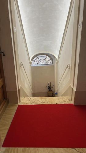 a red carpet in a room with a window at Palazzo Palloni Boutique Apartment in Sorano