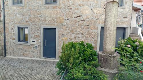 ein Steingebäude mit einer blauen Tür darauf in der Unterkunft Casa do Pelourinho - T0 in Loriga