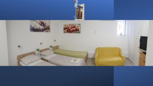 a living room with a couch and a yellow chair at Apartments Viking in Split