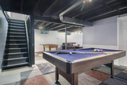 a pool table in a room with a staircase at 3 min to Beach, Game Room, Hot tub & Firepit in Traverse City
