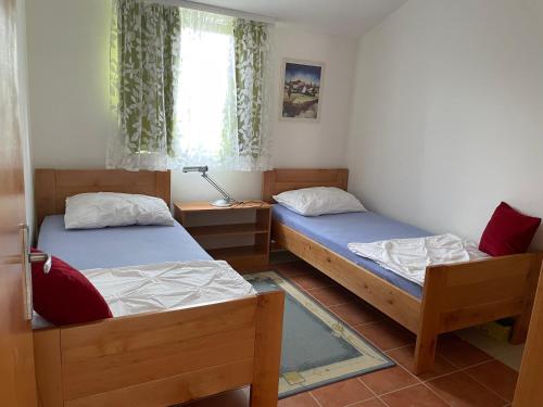 Cette chambre comprend 2 lits et une fenêtre. dans l'établissement Apartment Near The Beach, à Privlaka