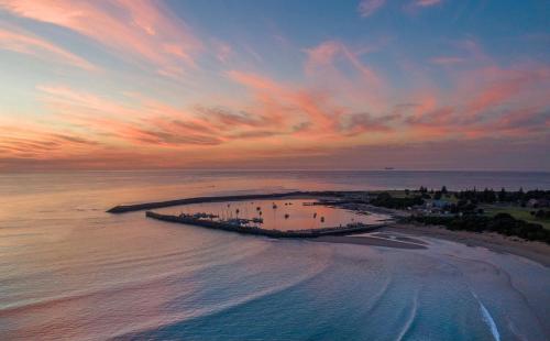 an aerial view of a beach at sunset at luxurious 4 Bedroom Ocean View Holiday House in Apollo Bay
