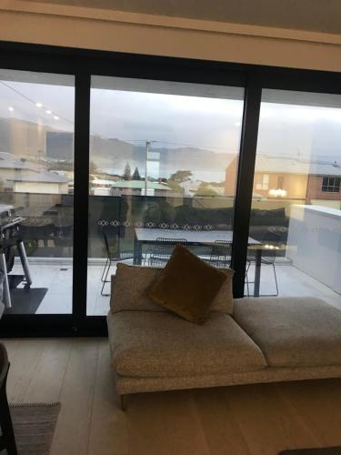 a couch in a living room with a large window at luxurious 4 Bedroom Ocean View Holiday House in Apollo Bay