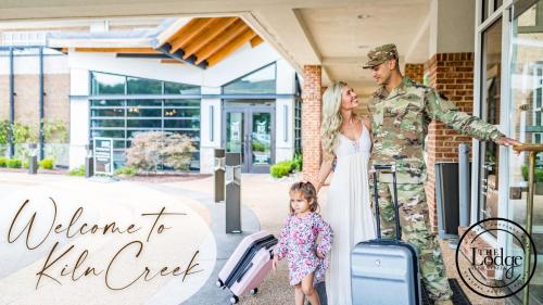 a soldier and a woman and a little girl with luggage at The Lodge at Kiln Creek Resort in Newport News