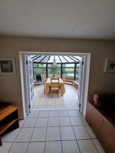 a dining room with a table and chairs in a house at Holly Lodge in Norwich
