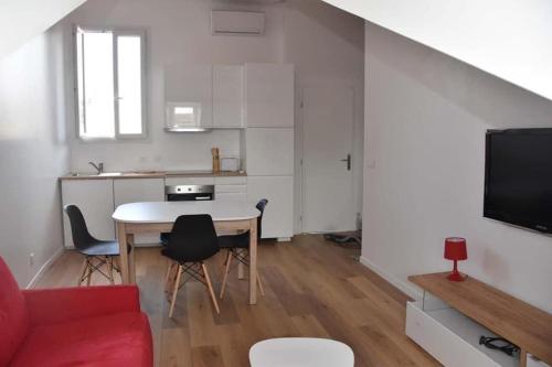 un salon avec une table et un canapé rouge dans l'établissement appartement à 100 m de la plage, à Cannes