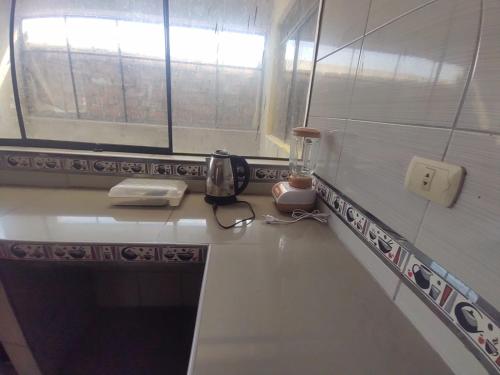 encimera de cocina con teléfono y ventana en BACKPAKERS MIRADOR, en Huaraz