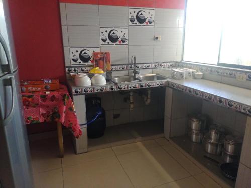 una pequeña cocina con fregadero y mesa en BACKPAKERS MIRADOR, en Huaraz