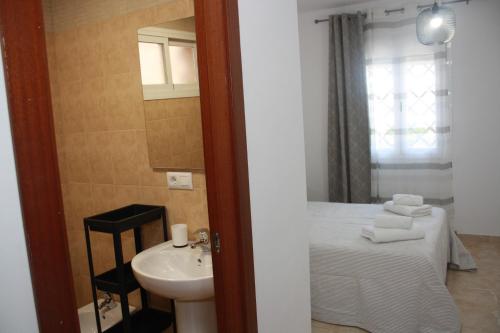 a bathroom with a sink and a bed in a room at Fuente Lebana Labradores in Facinas