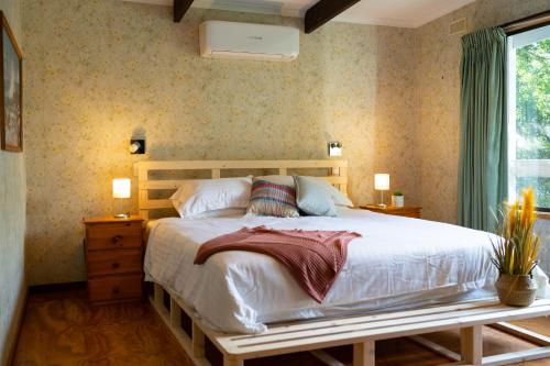 a bedroom with a large bed and a window at The View, Metung in Metung