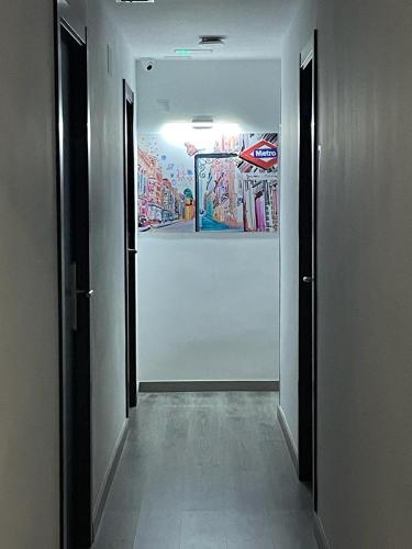a hallway with two doors and a painting on the wall at CH Bueno in Madrid