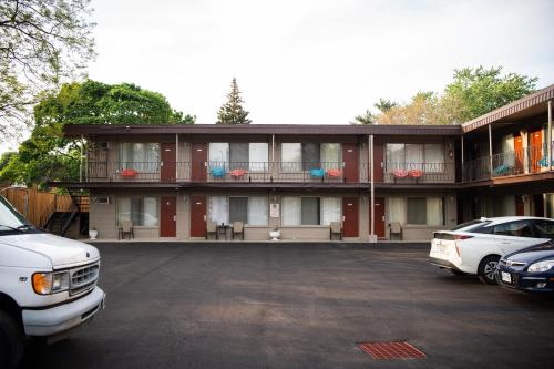 un edificio rojo con coches estacionados frente a él en Advance Inn, en Niagara Falls