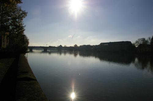 a river with the sun shining on the water at Hôtel de l'Abbaye des Prémontrés in Pont-à-Mousson