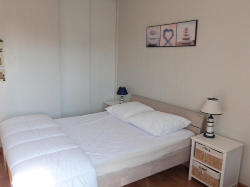 une petite chambre avec un lit blanc et une lampe dans l'établissement Maison ensoleillée proche plage de la Grière, 4 pers., terrasse, WiFi, parking privé - FR-1-194-239, à La Tranche-sur-Mer