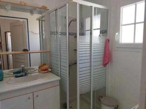 une salle de bain avec une douche, un lavabo et un miroir dans l'établissement Maison ensoleillée proche plage de la Grière, 4 pers., terrasse, WiFi, parking privé - FR-1-194-239, à La Tranche-sur-Mer