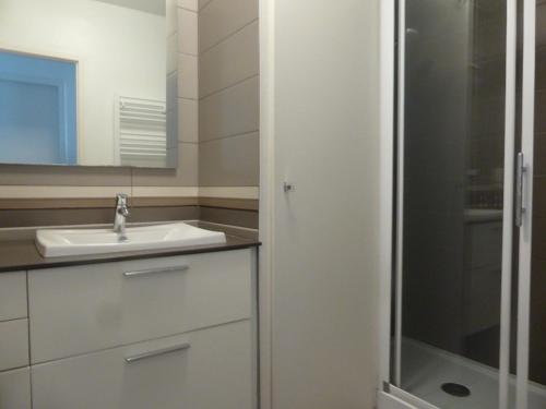 une salle de bain blanche avec un lavabo et une douche dans l'établissement Superbe T2 rénové face mer avec parking, proche plage et commerces, Les Sables d'Olonne - FR-1-325-69, à Les Sables-dʼOlonne