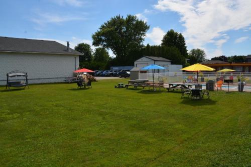 a group of picnic tables with umbrellas in a yard at Harmony Inn in Goderich