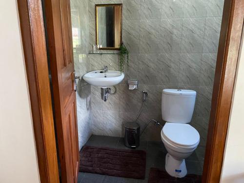 a bathroom with a toilet and a sink at Serongga guest house in Lebih