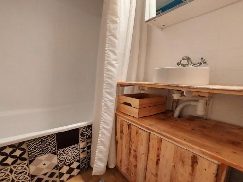 La salle de bains est pourvue d'un lavabo sur un comptoir en bois. dans l'établissement Charmant Studio au Centre de Samoëns - Balcon Exposé Sud, Parking et Animaux Acceptés - FR-1-624-110, à Samoëns