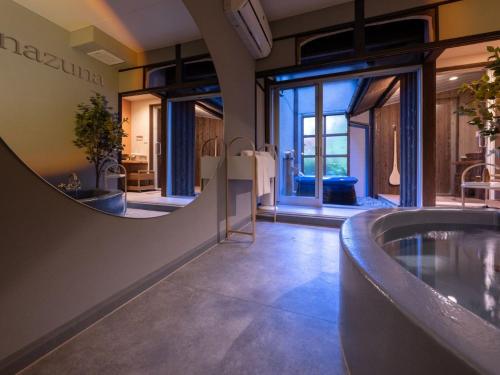 a bathroom with a tub and a large mirror at Nazuna Kyoto Nijo-jo in Kyoto