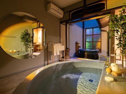 a large bath tub in a room with a large window at Nazuna Kyoto Nijo-jo in Kyoto