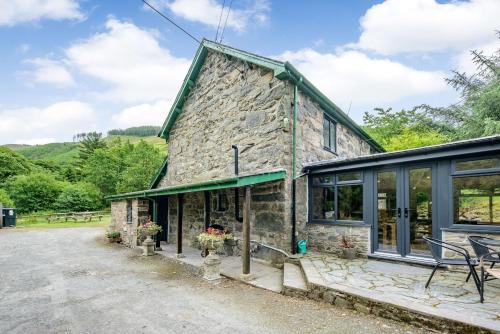 an old stone house with glass doors and windows at Groes Heol in Machynlleth