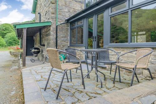 a group of chairs and a table on a patio at Groes Heol in Machynlleth