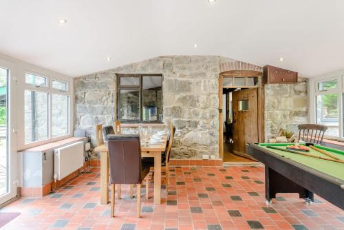 a dining room with a table and a pool table at Groes Heol in Machynlleth