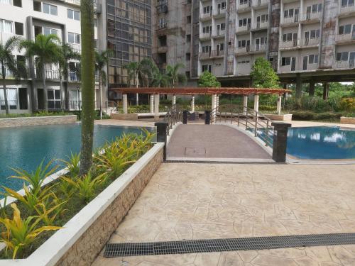 a walkway next to a pool in a building at Affordable Tagaytay Monteluce 1 BR WITH POOL in Lalaan Primero