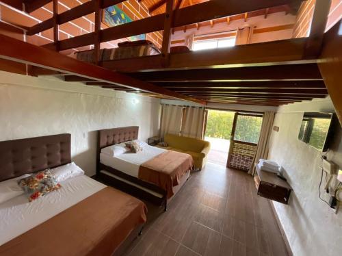 a bedroom with two beds and a couch in it at Finca-hotel Montecarlo Guatape by Hope in Guatapé