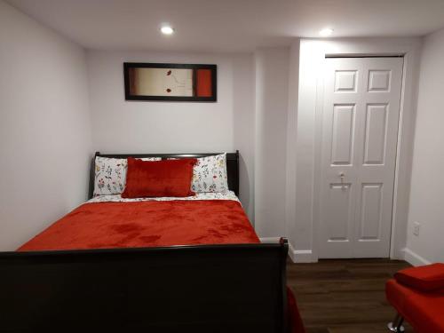 a bedroom with a bed with a red blanket at Motel LA RÉFÉRENCE in Trois-Rivières