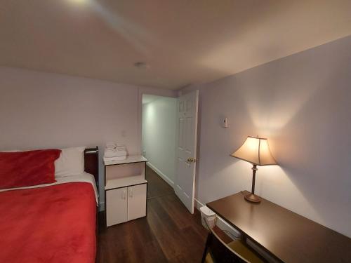 a bedroom with a bed and a desk with a lamp at Motel LA RÉFÉRENCE in Trois-Rivières