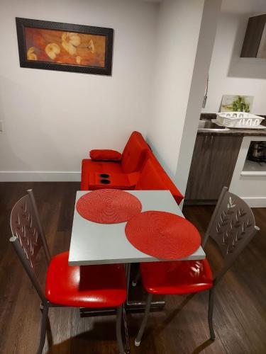 a dining room with a table and red chairs at Motel LA RÉFÉRENCE in Trois-Rivières