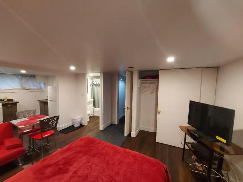 a bedroom with a red bed and a living room at Motel LA RÉFÉRENCE in Trois-Rivières
