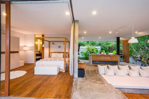 a bedroom with a bed and a living room at ROMANTIC GETAWAY - ARCHITECTURAL MASTERPIECE 1BR in Canggu